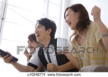 Young friends watching television View Large Photo Image Picture - Young friends watching television. Fotosearch