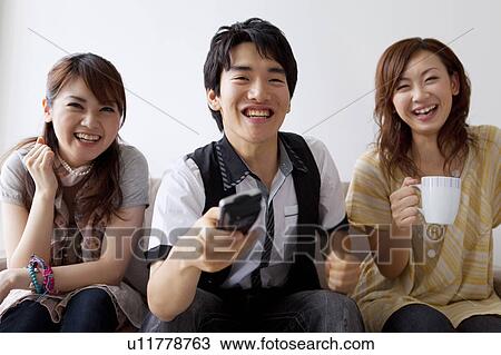 Stock Image - Young friends watching television. Fotosearch