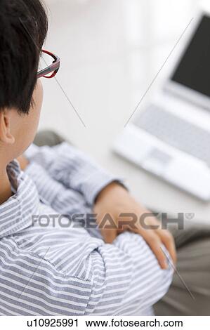 Young man looking at laptop View Large Photo Image Stock Image - Young man looking at laptop. Fotosearch