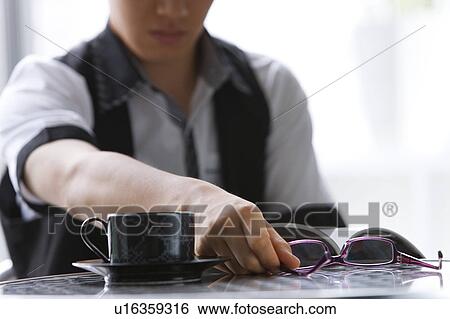 Young man reading a magazine at a cafe View Large Photo Image Stock Photograph - Young man reading a magazine at a cafe. Fotosearch