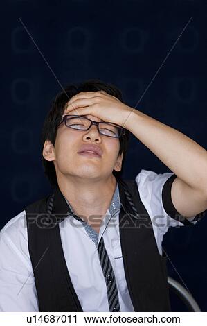 Young man touching forehead View Large Photo Image Stock Image - Young man touching forehead. Fotosearch