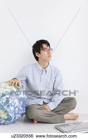 Stock Photograph - Young man wearing red glasses with laptop. Fotosearch