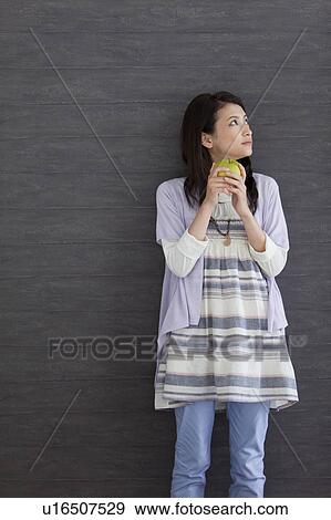 Young woman holding an apple View Large Photo Image Stock Photo - Young woman holding an apple. Fotosearch