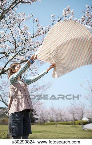 Young woman laying picnic blanket View Large Photo Image Picture - Young woman laying picnic blanket. Fotosearch