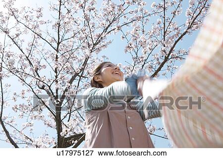 Stock Photo - Young woman laying picnic blanket. Fotosearch