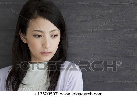 Stock Photo - Young woman looking down. Fotosearch