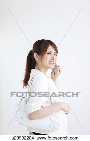 Young woman on a cell phone View Large Photo Image Picture - Young woman on a cell phone. Fotosearch