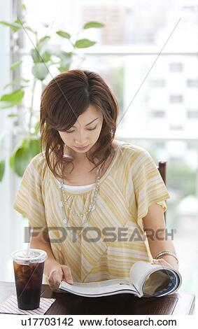 Young woman reading a magazine View Large Photo Image Stock Image - Young woman reading a magazine. Fotosearch