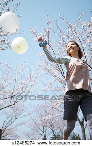 Picture - Young woman running with balloon. Fotosearch