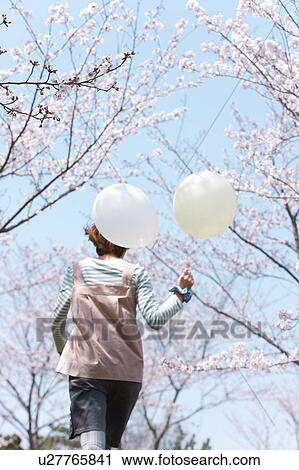 Young woman running with balloon, rear view View Large Photo Image Stock Image - Young woman running with balloon, rear view. Fotosearch