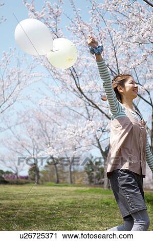 Young woman running with balloon View Large Photo Image Stock Image - Young woman running with balloon. Fotosearch