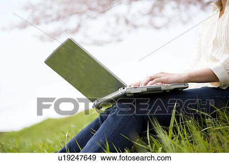 Young woman using laptop View Large Photo Image Stock Photo - Young woman using laptop. Fotosearch