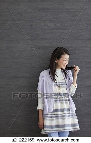 Stock Photo - Young woman with hand in hair. Fotosearch