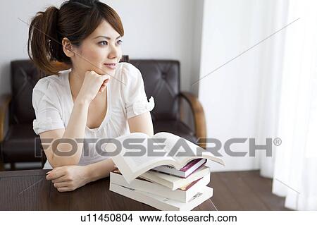 Picture - Young woman with hand on chin. Fotosearch