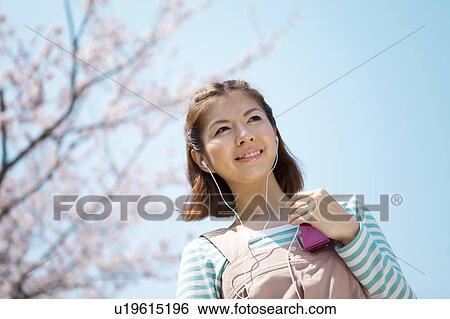 Stock Photograph - Young woman with headphones on. Fotosearch