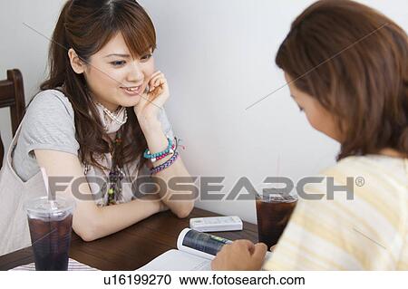 Young women at a cafe View Large Photo Image Stock Image - Young women at a cafe. Fotosearch