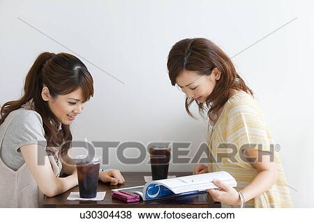 Young women at a cafe View Large Photo Image Stock Photo - Young women at a cafe. Fotosearch