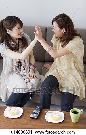 Young women high-fiving View Large Photo Image Stock Image - Young women high-fiving. Fotosearch