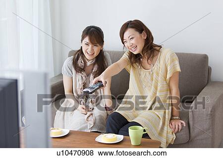 Young women watching television View Large Photo Image Stock Photo - Young women watching television. Fotosearch