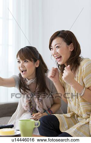 Young women watching television View Large Photo Image Stock Photograph - Young women watching television. Fotosearch