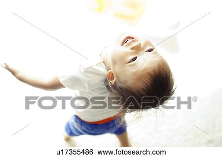 Stock Photograph - Baby Boy Bending Backwards and Looking Up. Fotosearch
