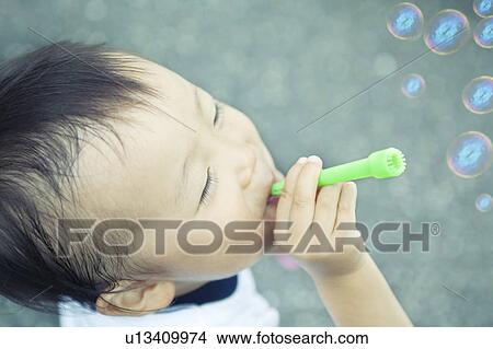 Picture - Baby Boy Blowing Bubbles. Fotosearch