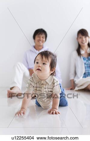 Baby Boy Crawling, Parents in Background View Large Photo Image Picture - Baby Boy Crawling, Parents in Background. Fotosearch