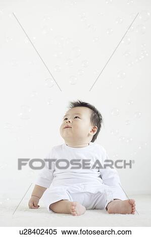 Stock Photography - Baby Boy Looking Up at Bubbles. Fotosearch