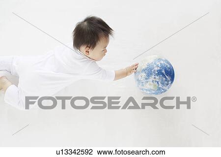 Stock Image - Baby Boy Playing With Globe, High Angle View. Fotosearch
