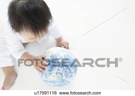 Stock Photograph - Baby Boy Playing With Globe, High Angle View. Fotosearch