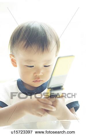 Stock Photo - Baby Boy Text Messaging. Fotosearch