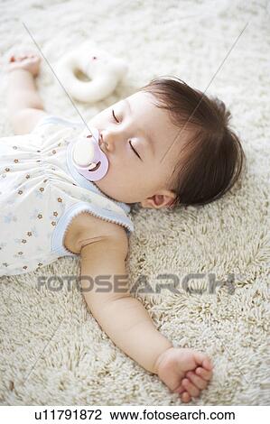 Baby lying down on carpet sleeping View Large Photo Image Stock Image - Baby lying down on carpet sleeping. Fotosearch