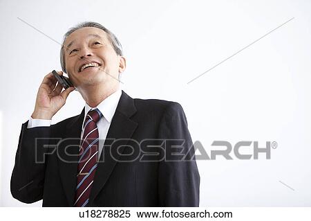 Stock Photography - Businessman on Mobile Phone, Low Angle View. Fotosearch