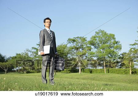 Stock Photo - Businessman Standing in Park. Fotosearch