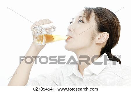 Stock Image - Businesswoman drinking a glass of beer, Tokyo Prefecture, Japan. Fotosearch