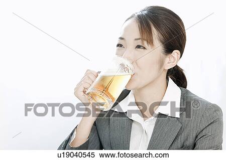 Stock Photography - Businesswoman drinking a glass of beer, Tokyo Prefecture, Japan. Fotosearch