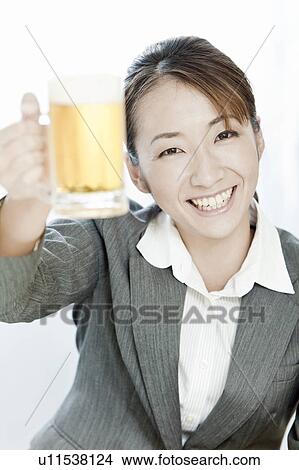 Businesswoman holding a glass of beer, Tokyo Prefecture, Japan View Large Photo Image Picture - Businesswoman holding a glass of beer, Tokyo Prefecture, Japan. Fotosearch