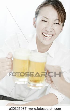 Stock Photo - Businesswoman toasting beer, Tokyo Prefecture, Japan. Fotosearch