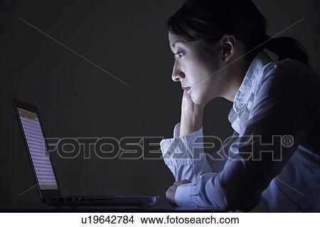 Businesswoman using laptop in the dark, Tokyo Prefecture, Japan View Large Photo Image Picture - Businesswoman using laptop in the dark, Tokyo Prefecture, Japan. Fotosearch
