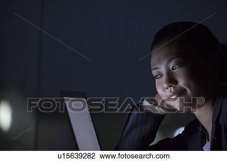 Businesswoman using laptop in the dark, Tokyo Prefecture, Honshu, Japan View Large Photo Image Stock Image - Businesswoman using laptop in the dark, Tokyo Prefecture, Honshu, Japan. Fotosearch