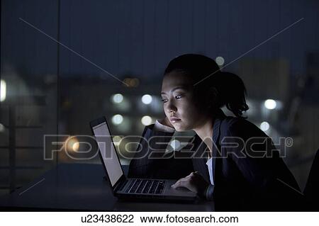 Businesswoman using laptop in the dark, Tokyo Prefecture, Honshu, Japan View Large Photo Image Stock Image - Businesswoman using laptop in the dark, Tokyo Prefecture, Honshu, Japan. Fotosearch