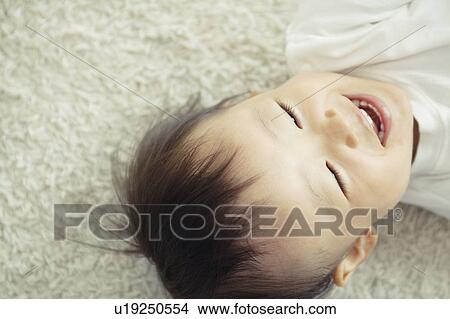 Picture - Cheerful Baby Boy Lying on Floor. Fotosearch