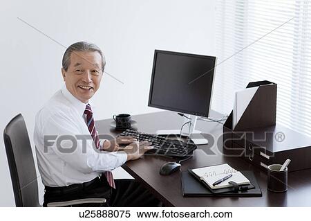 Stock Photography - Cheerful Businessman at Desk. Fotosearch
