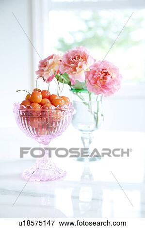 Stock Photo - Cherries in a glass and roses in vase. Fotosearch
