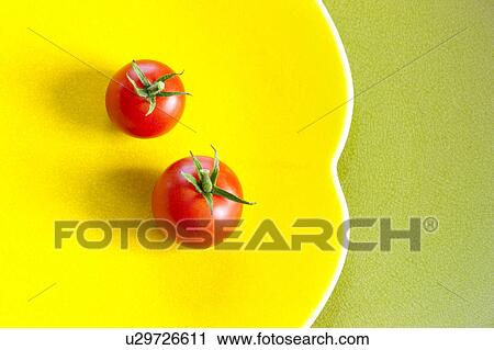 Stock Image - Cherry Tomatos on Yellow Plate. Fotosearch