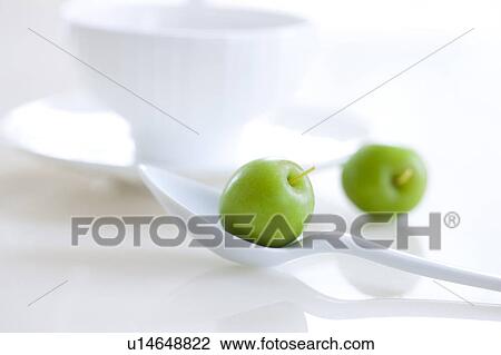 Stock Image - Chinese Crabapple on Spoon Beside Porcelain Coffee Cup. Fotosearch