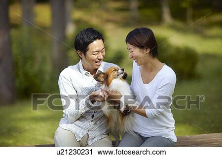 Stock Image - Couple and Papillon Dog. Fotosearch