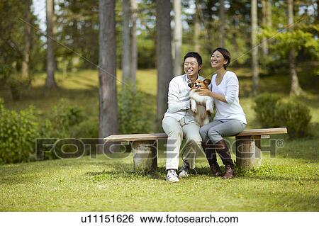 Couple With Dog Sitting on Bench in Park View Large Photo Image Stock Photograph - Couple With Dog Sitting on Bench in Park. Fotosearch
