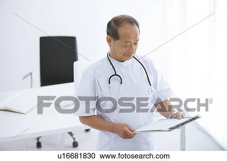 Stock Image - Doctor Reading Document. Fotosearch
