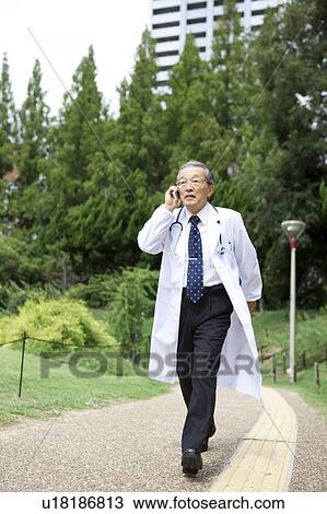 Doctor Walking and Talking On The Phone View Large Photo Image Stock Image - Doctor Walking and Talking On The Phone. Fotosearch
